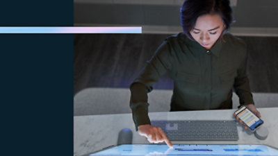 A person using a laptop with a finger pointing at the keyboard.