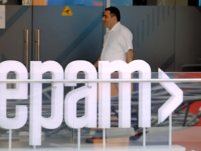 A man walking in front of a glass wall with visible text epam.