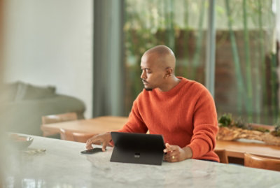 A person sitting at a table using a laptop.