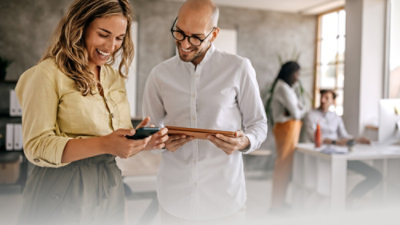 A man and woman looking at a tablet.