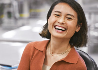 A women with short hairs laughing.