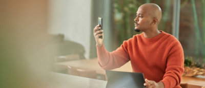 A man taking a selfie sitting infront of laptop