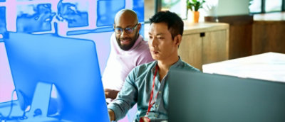 Two persons working on computer and smiling
