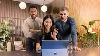 A group of people looking at a laptop.