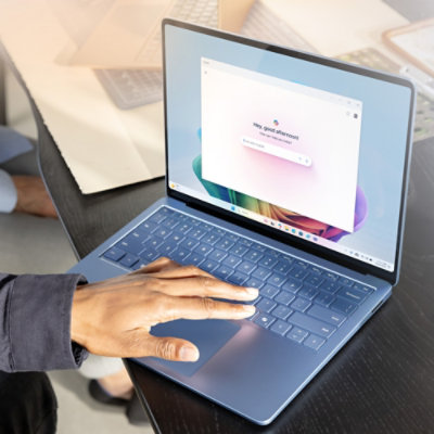 A hand on a laptop keyboard.
