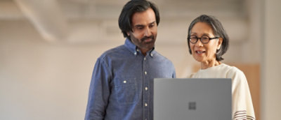 Two people are looking at a laptop screen