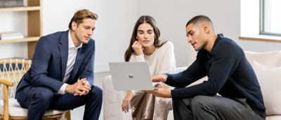 Three presons sitting together and looking into laptop.