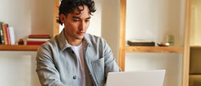 A man sitting on the floor using a laptop.