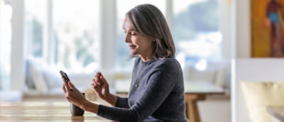A women holding mobile speaking to someone.