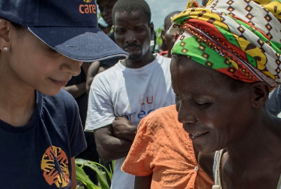 群衆の中に立っている人々のグループと、「care 00%」というテキスト。