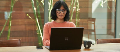 A women sitting at desk work on laptop