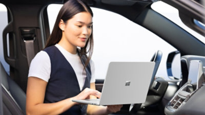 A person in a car using a laptop.