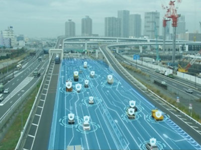 A road with cars on it surrounded by fog with buildings in the distance.