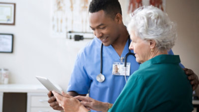 Doktor sa stetoskopom i dama koja gleda u ekran