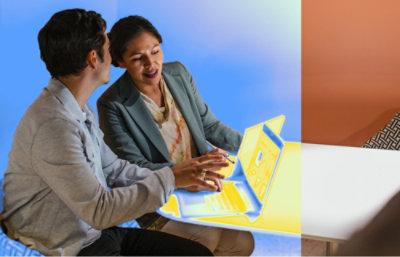 Two people sitting at a table, discussing work while using a laptop with a bright digital overlay.