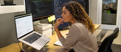 A woman sitting at the table and looking at a computer