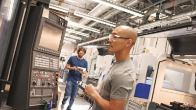 En mann i en fabrikk som holder en notatblokk.