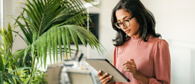 Una mujer de pie sosteniendo una pestaña.