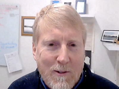 A close-up view of a man's mouth with a beard visible.