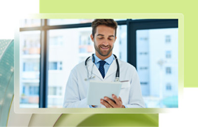 A doctor holding and looking at a tablet.