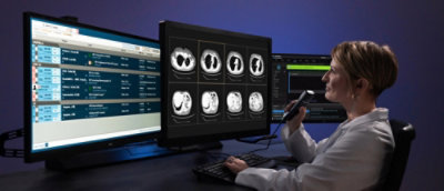 A person sitting at a desk with a computer and a telephone.