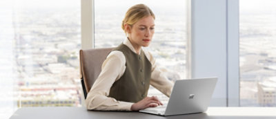 A women sitting at desk work on laptop