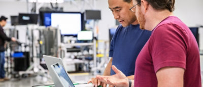 A man in a blue shirt looking at a computer screen.
