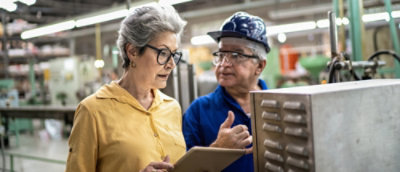 A man and woman looking at a tablet.