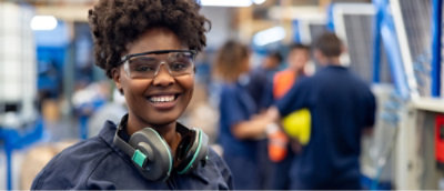 A woman wearing protective glasses and headphones.
