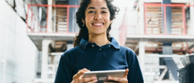 Žena, která drží tablet a usmívá se.