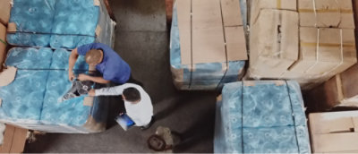 Muž ve skladu, který drží tablet.