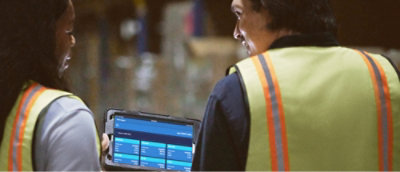 Muž v reflexní vestě, který má v ruce notebook.