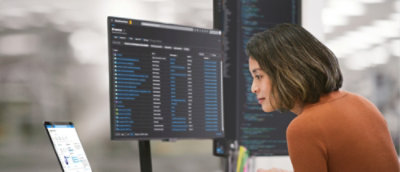 A woman with short brown hair looking at a computer screen.