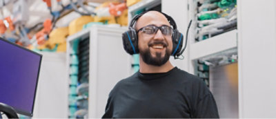 A man wearing headphones and smiling.