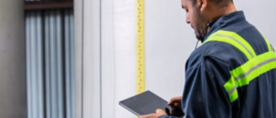 A man in a blue jacket holding a tablet.