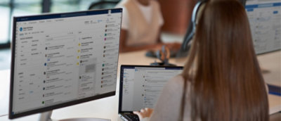 Uzun saçlı bir kadın bilgisayar başında çalışıyor.