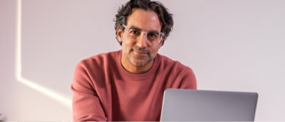 Un hombre con gafas y una camiseta rosa.