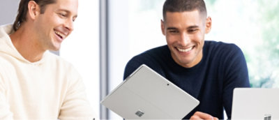 Dos hombres mirando un portátil.