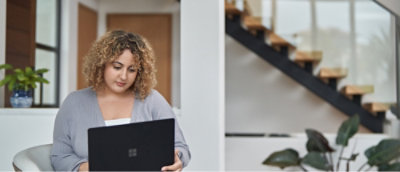 A woman with curly hair looking at a laptop.