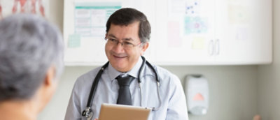 En mann med briller og et stetoskop rundt halsen.