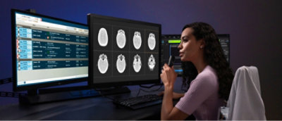 En kvinne i en lilla skjorte ser på en dataskjerm