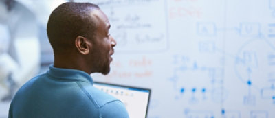 A man with short hair and a beard looking at a computer screen.