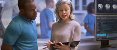 A woman with grey hair holding a tablet.