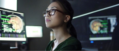 A woman wearing glasses looking up.
