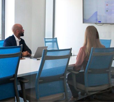 Un bărbat și o femeie uitându-se la un ecran.