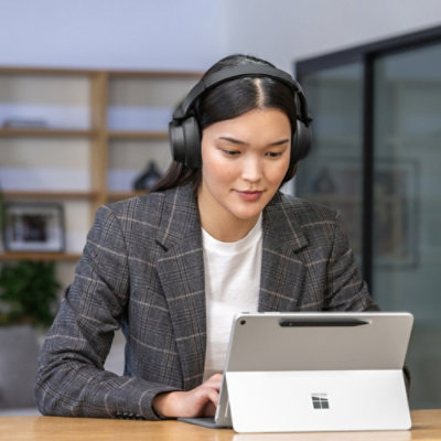 ヘッドホンを着けた人がタブレットを見ています。