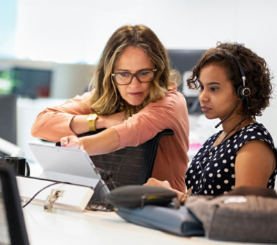 ノート PC で何かをチェックしている 2 人のユーザー