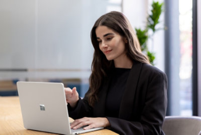 A woman sitting at a table using a laptop.