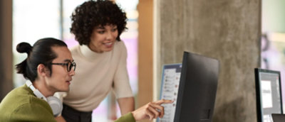 A man and women looking at the laptop screen and discussing