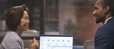 A man and women looking at the laptop screen and discussing